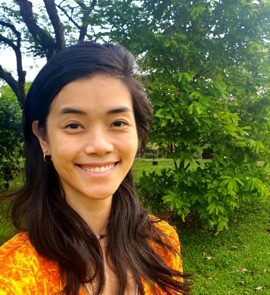 Headshot of counsellor and play therapist Adeline Chang, smiling in the park.